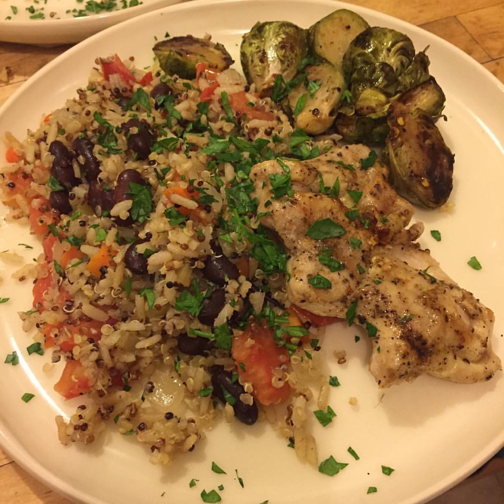 A balanced plated meal of brown rice, quinoa, grilled chicken, and broccoli